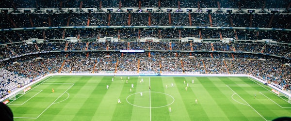 全景机位视角 - 体育场广角画面，展现全场阵型与跑动